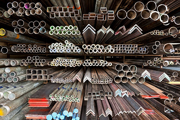 Various angle iron profiles and steel rods kept in storage shelves in a steel shop.